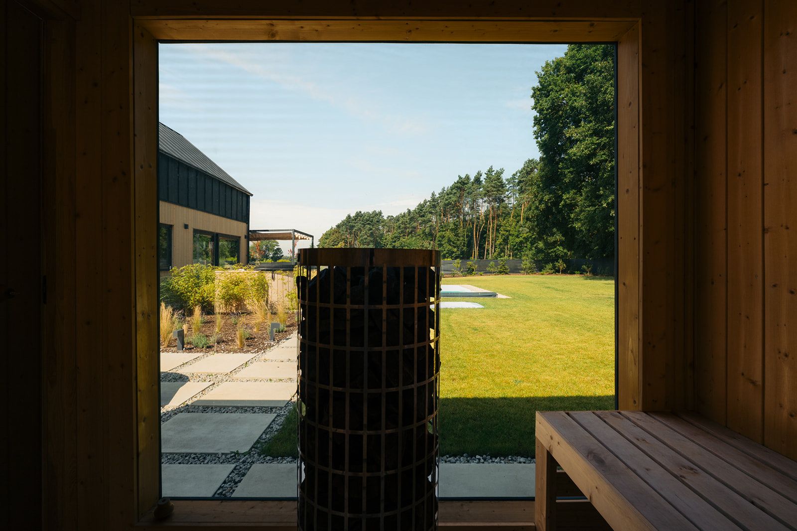 Widok z sauny na ogród i basen. Prywatna sauna ogrodowa w Blissko.